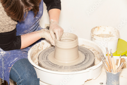 Female Potter creating a earthen jar on a Potter's wheel
