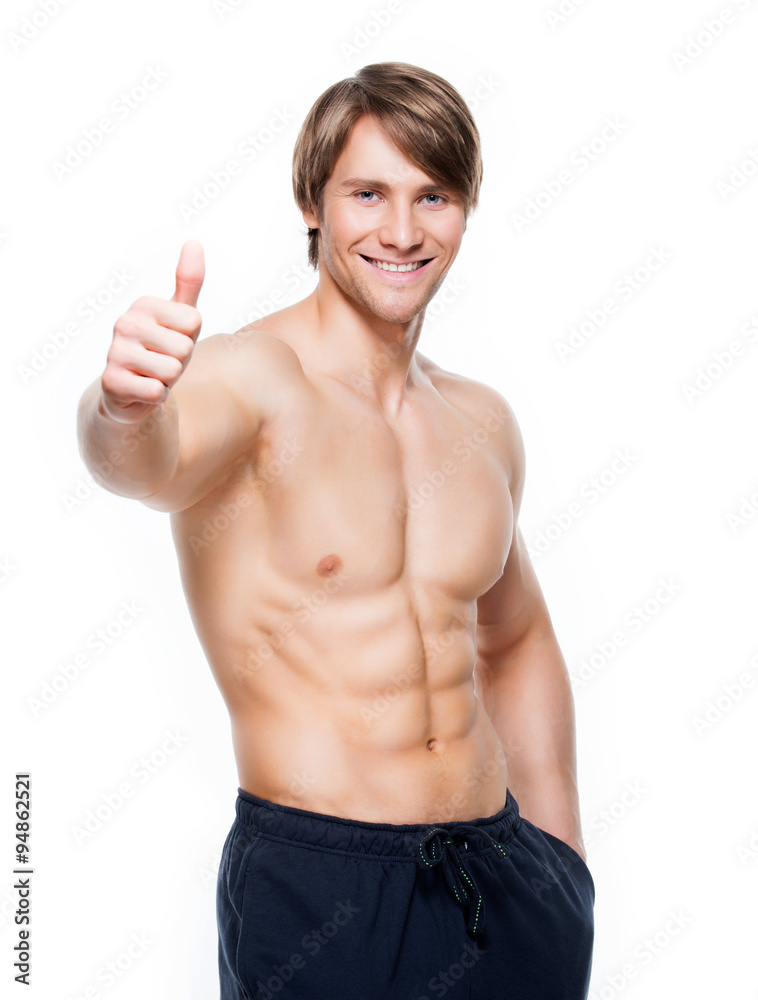 Man with muscular torso shows thumbs up sign. Man with muscular torso shows thumbs up sign.