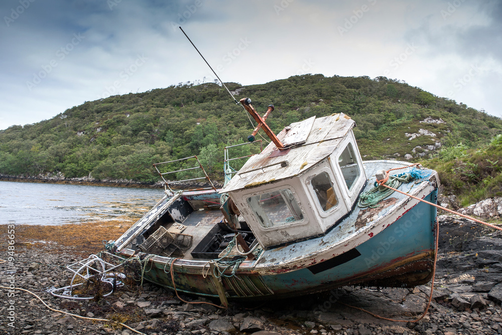 abandoned fishing boat lying on a rocky beach on the Isle of Lewis, Outer Hebrides, Scotland, UK, Europe 