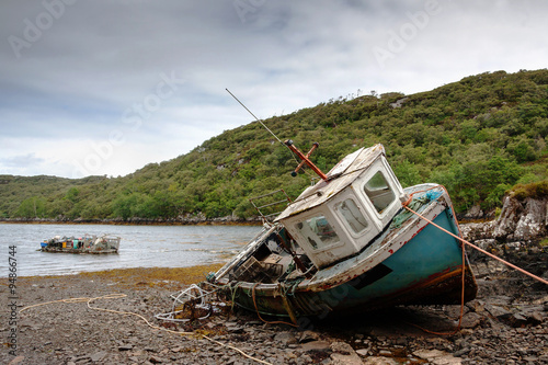 abandoned fishing boat lying on a rocky beach on the Isle of Lewis, Outer Hebrides, Scotland, UK, Europe 