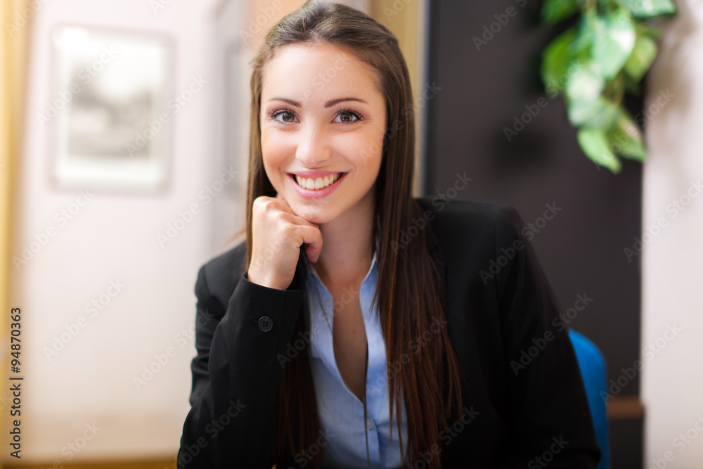 Beautiful young businesswoman sitting in her office Beautiful young businesswoman sitting in her office