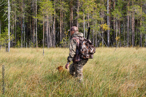 hunter with dog on the swamp on autumn hunting