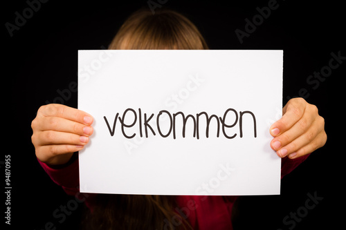 Child holding sign with Danish word Velkommen - Welcome photo