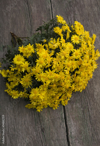 bouquet of yellow flowers lying on an old wooden table