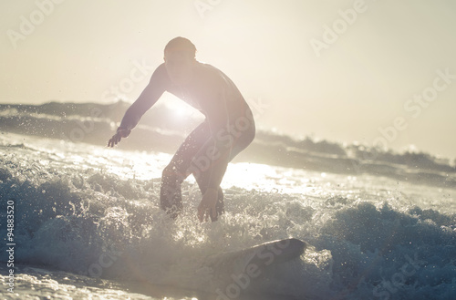 Surfer getting on the wave with his board