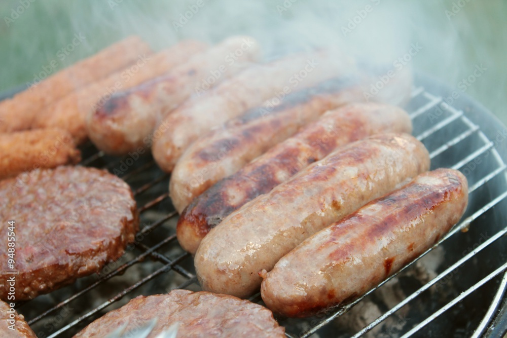sausages and burgers cooking on barbecue sausages and burgers cooking on barbecue