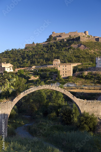Ancient stone arch bridges with a background of Parador de Cardona  a 9th Century medieval hillside Castle  near Barcelona  Catalonia  Cardona  Spain