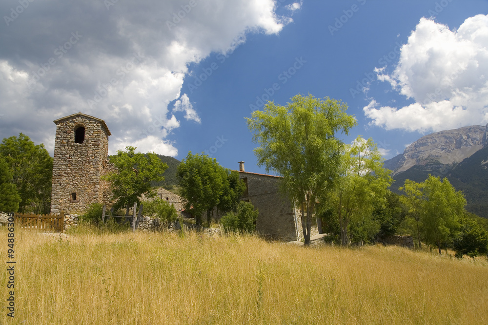 Fototapeta premium Old church tower and blue sky in Pyrenees Mountains, near La Seu d'Urgell, Cataluna, and Ansovell, province of Lleida, off N-260 Road, Spain, Europe