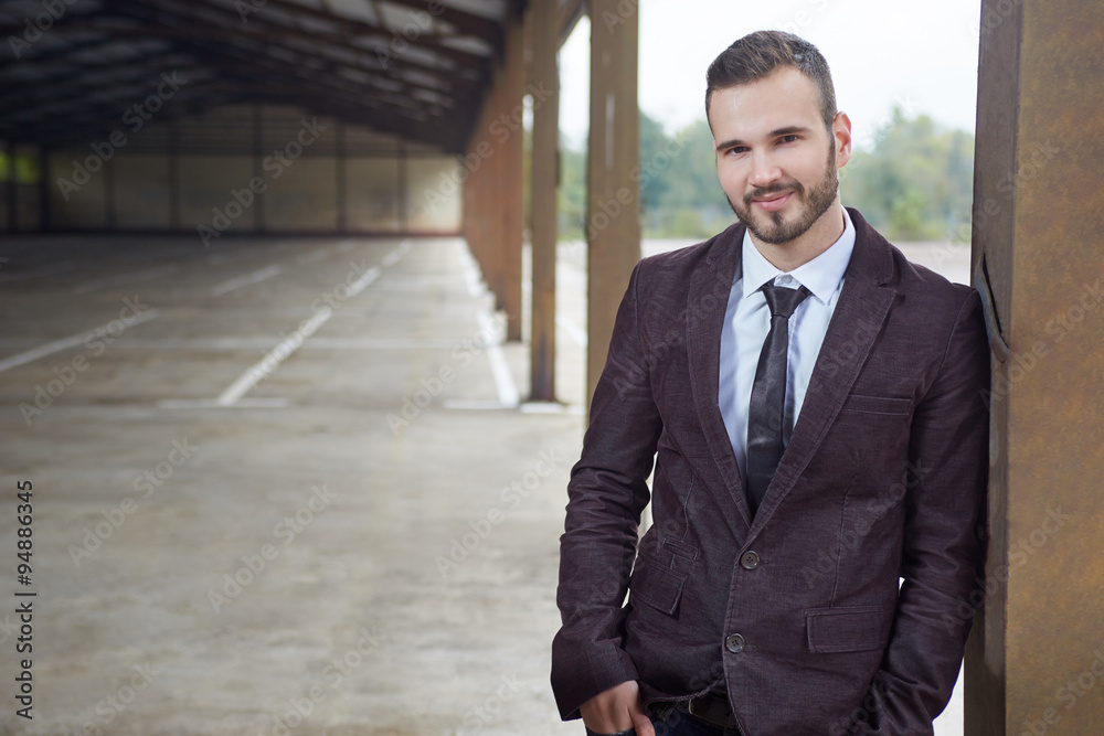 Smiling business man standing outside office building Smiling business man standing outside office building