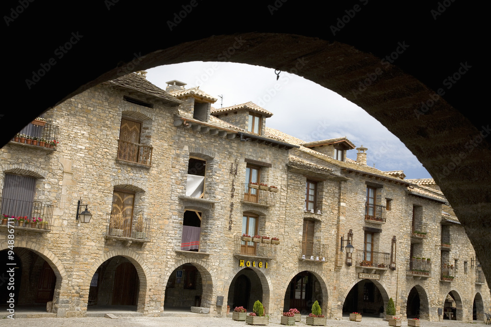 Arch view of Plaza Mayor, in Ainsa, Huesca, Spain in Pyrenees Mountains, an old walled town with hilltop views of Cinca and Ara Rivers