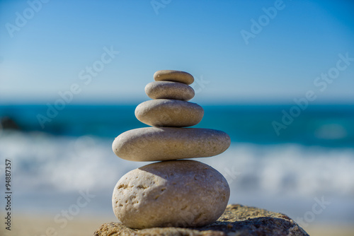 Stones balance, pebbles stack over blue sea in Croatia.