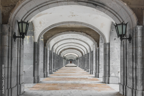 Symmetrical corridor with rows of columns. Black and white picture.