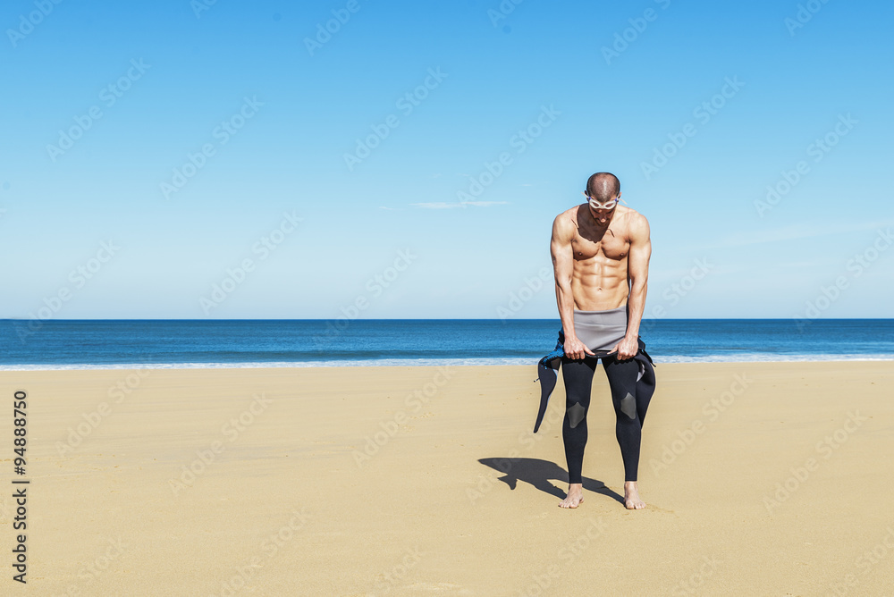 swimmer putting on his wetsuit