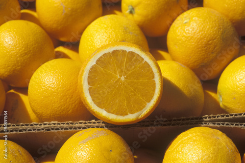 A halved orange rests on oranges in boxes in Ventura County  CA