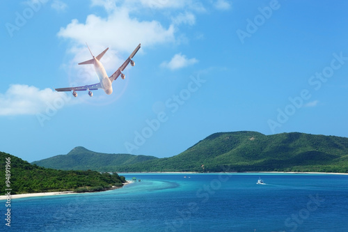 passenger plane flying over beautiful blue ocean and island in purity destination sea beach use for summer holiday vacation traveling