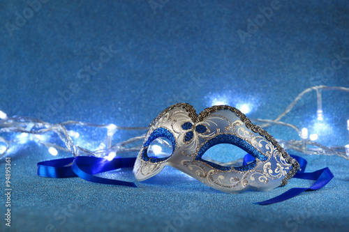 blue female carnival mask and glitter background