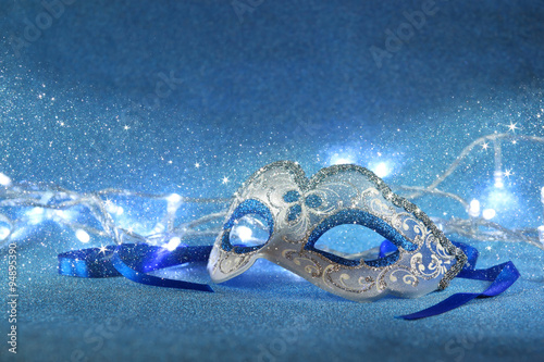blue female carnival mask and glitter background 