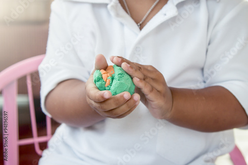 Child hand playing with clay, play doh