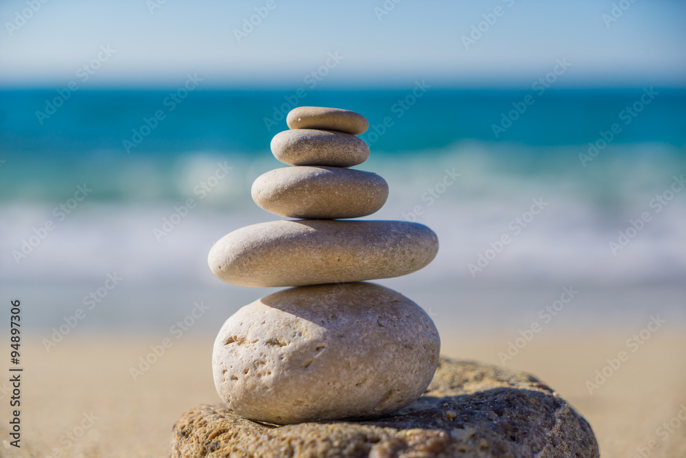 Stones pyramid on sand symbolizing zen, harmony, balance. Ocean Stones pyramid on sand symbolizing zen, harmony, balance. Ocean