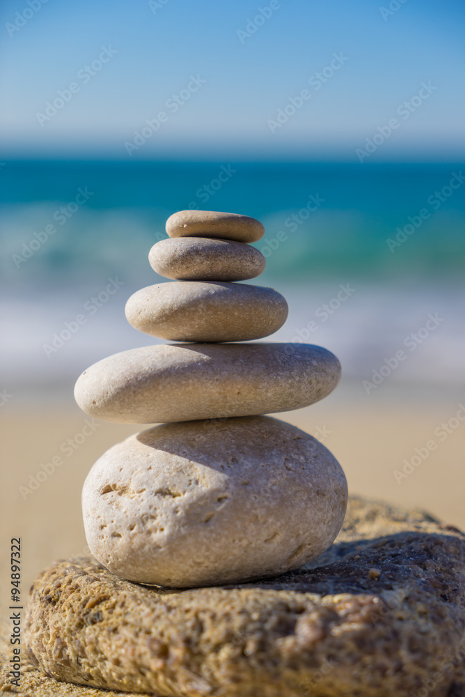Stones pyramid on sand symbolizing zen, harmony, balance. Ocean Stones pyramid on sand symbolizing zen, harmony, balance. Ocean