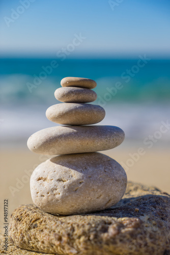 Stones pyramid on sand symbolizing zen  harmony  balance. Ocean