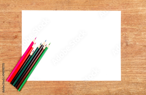 white paper with color pencil on wooden table