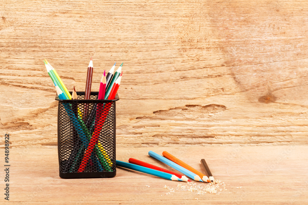 Color pencils on wooden background