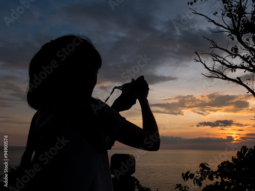 Silhouette girl taking photo when sunset with copy space