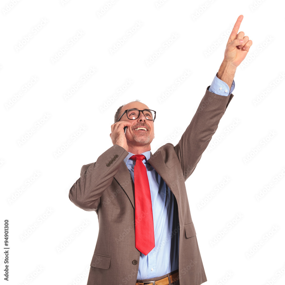 winning old businessman talking on the phone pointing up winning old businessman talking on the phone pointing up