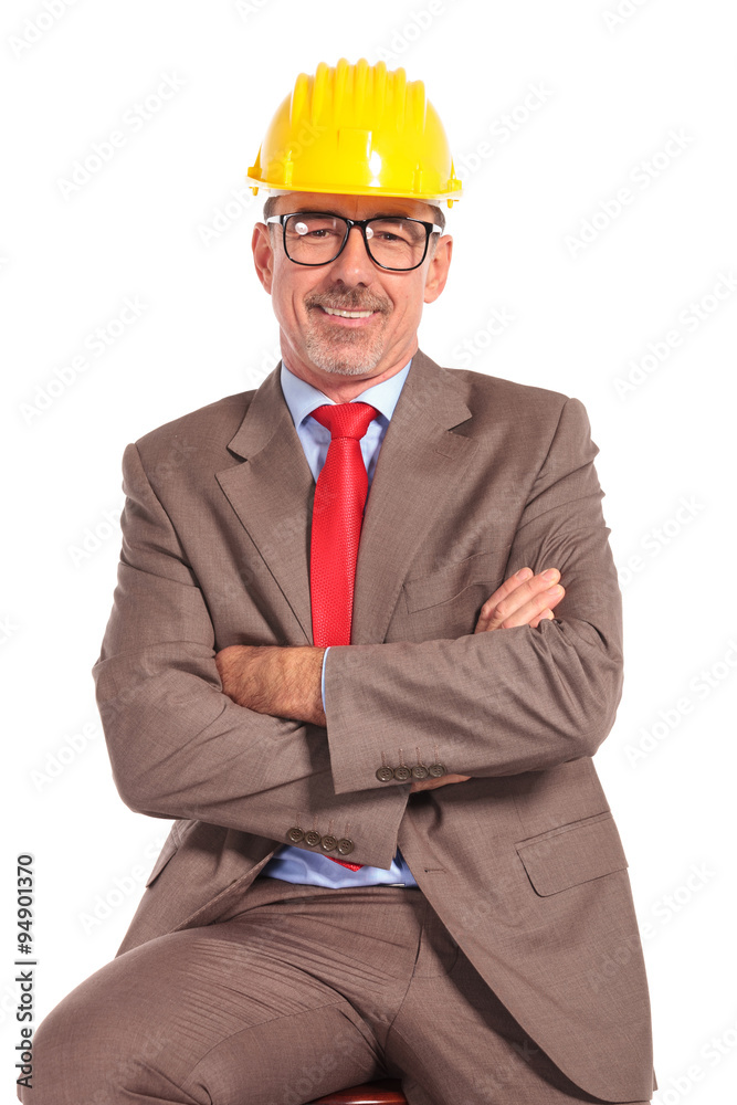 smiling old construction engineer sitting with hands crossed smiling old construction engineer sitting with hands crossed