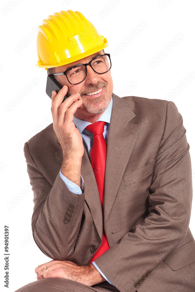 senior construcion engineer talking on the phone and looks away senior construcion engineer talking on the phone and looks away