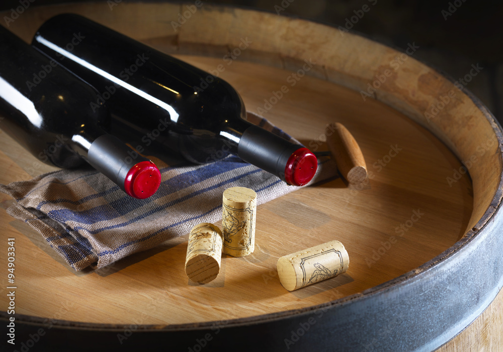 Obraz premium bottles of wine and corks on a barrel