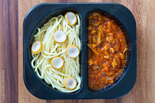 Spaghetti with red tomato sauce in a plastic box