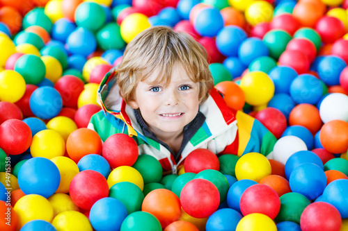 child playing at colorful plastic balls playground