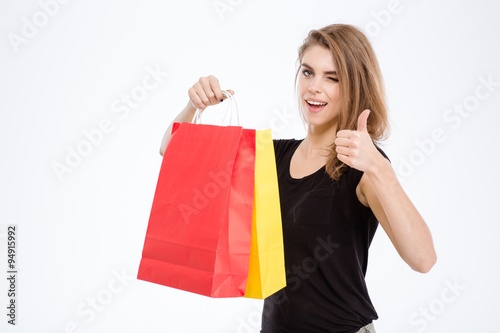 Woman holding shopping bags and showing thumb up