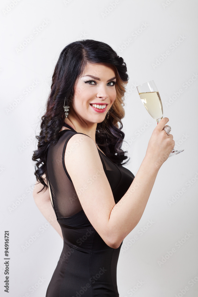 Beautiful young woman celebrating with a glass of champagne - obrazy, fototapety, plakaty 
