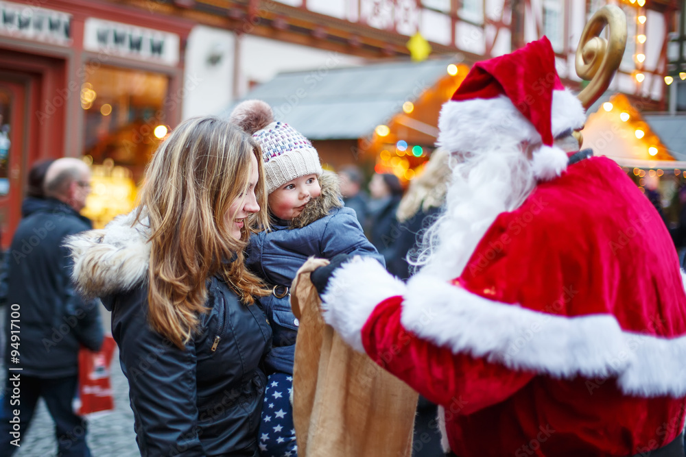 Little toddler girl with mother on Christmas market. Little toddler girl with mother on Christmas market.