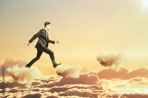Businessman is walking on clouds in the sky concept © Who is Danny