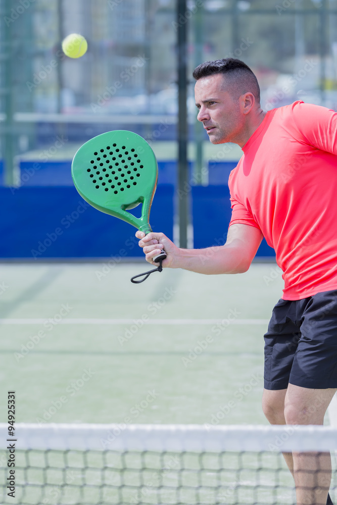 man playing paddle outdoors.