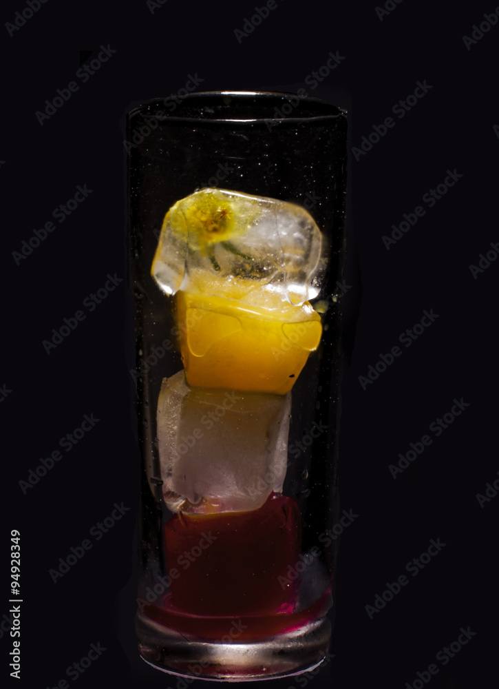 Glass of colored ice cubes isolated on black Glass of colored ice cubes isolated on black