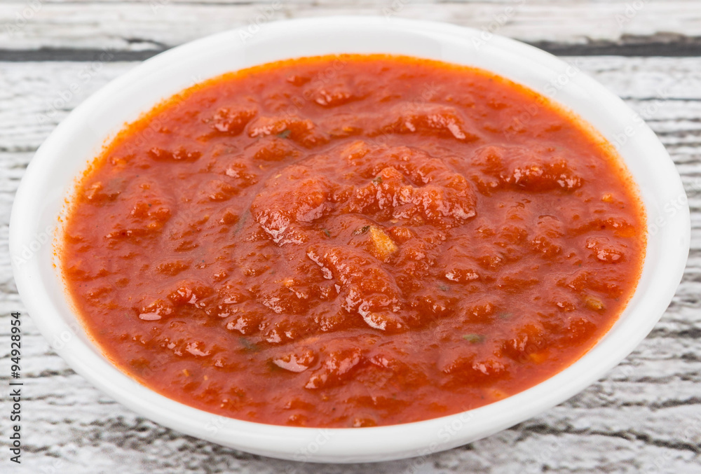 Spaghetti sauce in a white bowl over wooden background Spaghetti sauce in a white bowl over wooden background