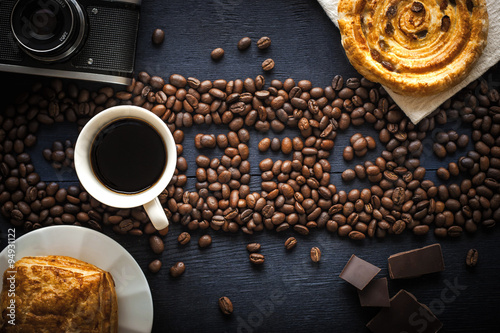 Coffee word made by coffee beans with camera chocolate , pastry and cup of coffee