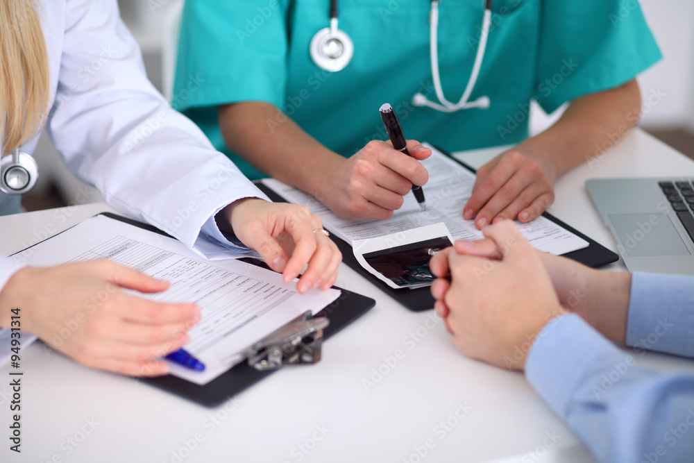 Doctors and patient are discussing something, just hands at the table Doctors and patient are discussing something, just hands at the table