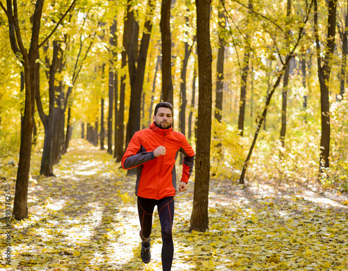 Young Man Running on Sunny Trail in the Beautiful Autumn Oak Forest