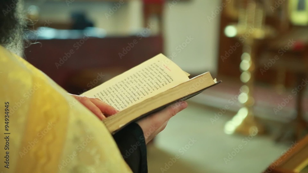 The priest in the Church shatters the page in the Bible The priest in the Church shatters the page in the Bible