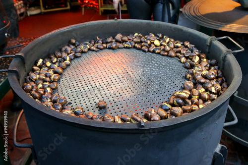 Roasted Sweet Chestnuts on a huge metal pot for sale during Christmas in Innsbruck, Austria photo