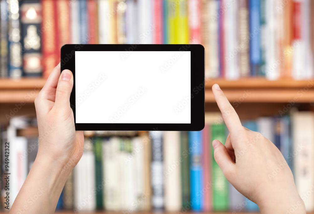 hand holds tablet pc and book shelves
