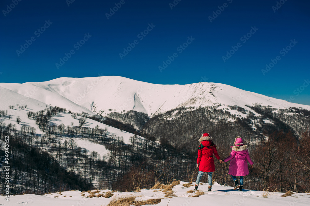 Back view of two young women friends on the background of snowy