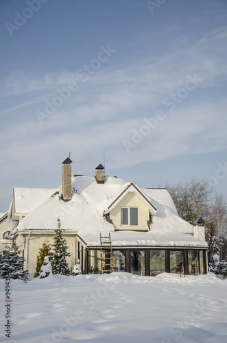 a private house and its garden under snow in winter