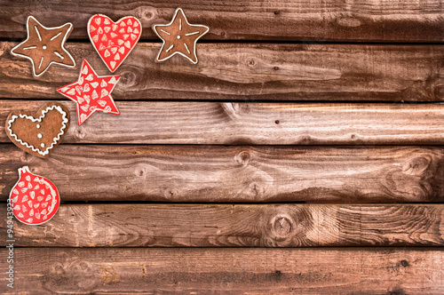 Ginger bread cookies and Christmas ornaments on wooden planks background